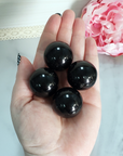 Black Obsidian Natural Crystal Sphere Gemstone Orb Marble - One 30mm Sphere - Group of Black Obsidian Orbs in Hand