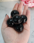 Black Obsidian Natural Crystal Sphere Gemstone Orb Marble - One 30mm Sphere - Group of Black Obsidian Crystal Orbs on Palm