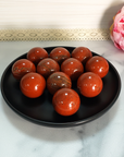 Red Jasper Natural Gemstone Sphere Crystal Orb Marble - One 30mm Sphere - Group of Red Jasper Stone Orbs on Black Ceramic Dish