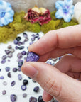 charoite stone between fingers
