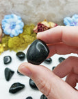 green goldstone crystal between fingers