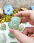 hand pinching green included quartz crystal