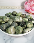 Infinite Serpentine Stone Natural Gemstone Tumbled Crystal - on White Ceramic Plate
