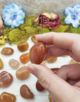 red aventurine crystals pinched between fingers