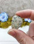 hand pinching white opal
