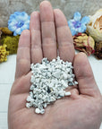Hand holding one ounce of howlite chips