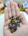 Hand holding one ounce of mixed gemstone crystal chips