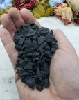 hand holding rough shungite stone chips