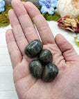 Camouflage jasper stone pieces in hand