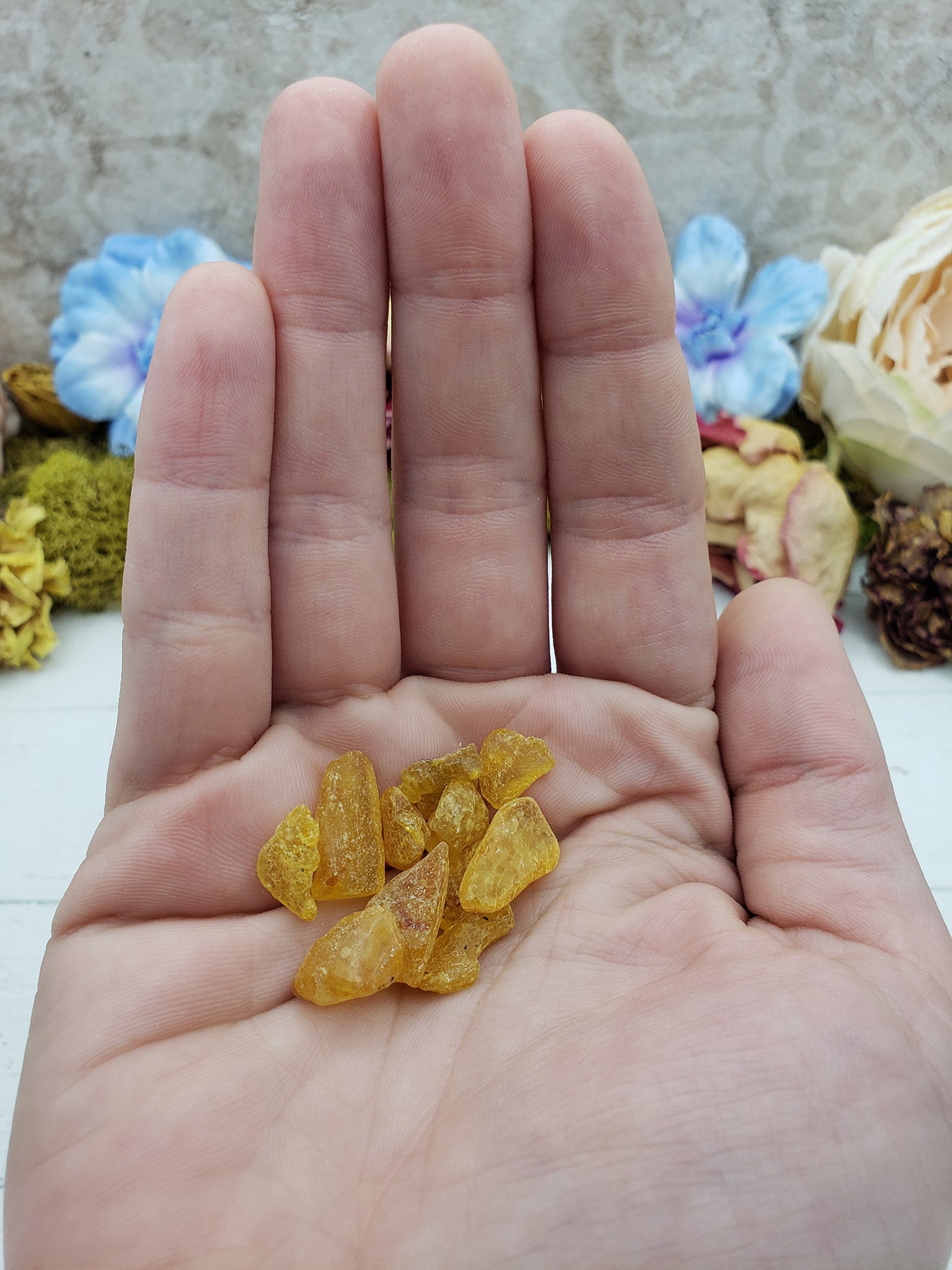 hand holding 3 grams of amber stone chips