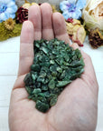 Hand holding three ounces of green aventurine chips
