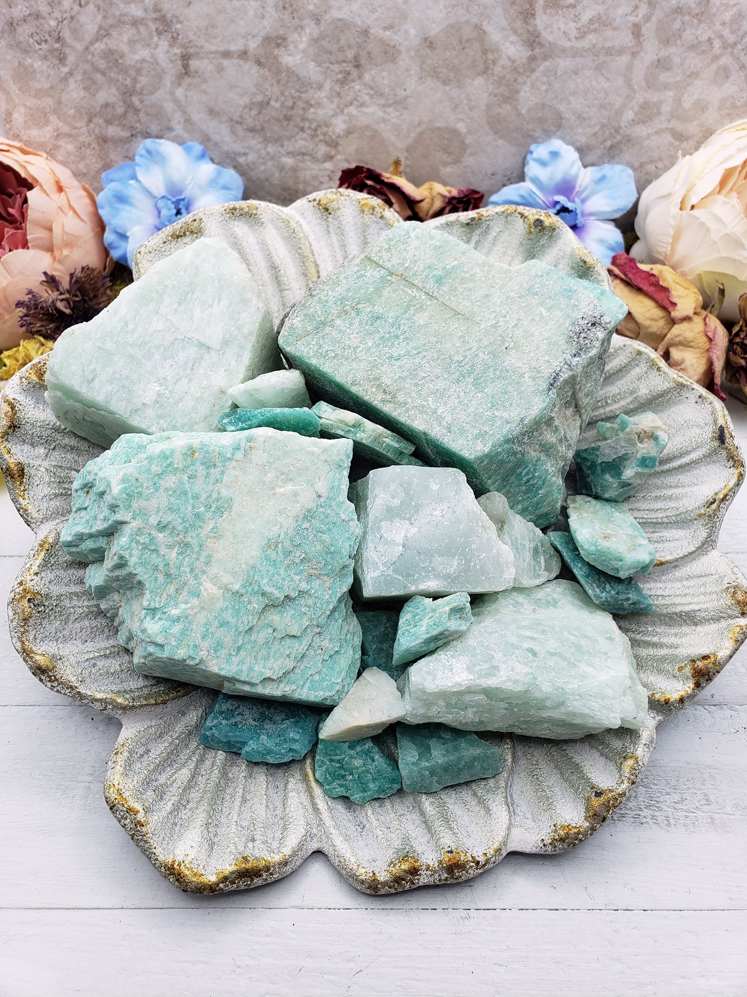 Collection of rough amazonite stones on floral dish