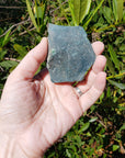 Hand holding rough bloodstone crystal