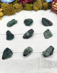 nine rough emerald stones on display