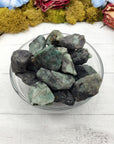 rough emerald stone pieces in bowl