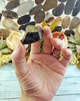 hand holding one rough epidote crystal