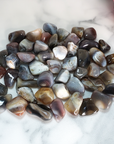 Botswana Agate Tumbled Gemstone - Single Stone - On Tile Large Group Close Up