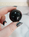 Black Obsidian Natural Crystal Sphere Gemstone Orb Marble - One 30mm Sphere - One Black Obsidian Crystal Orb Between Forefinger and Thumb