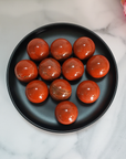 Red Jasper Natural Gemstone Sphere Crystal Orb Marble - One 30mm Sphere - Group of Red Jasper Crystal Spheres on Black Ceramic Dish