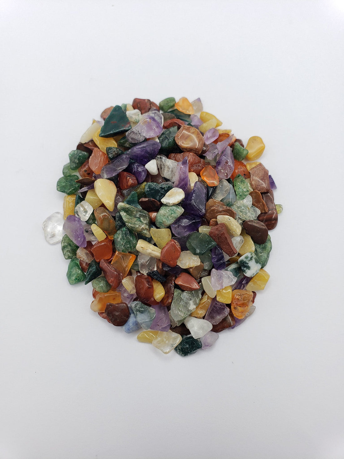 One ounce of mixed gemstone crystal chips on white backgroun
