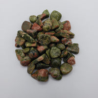 1 ounce of unakite stone chips on white background