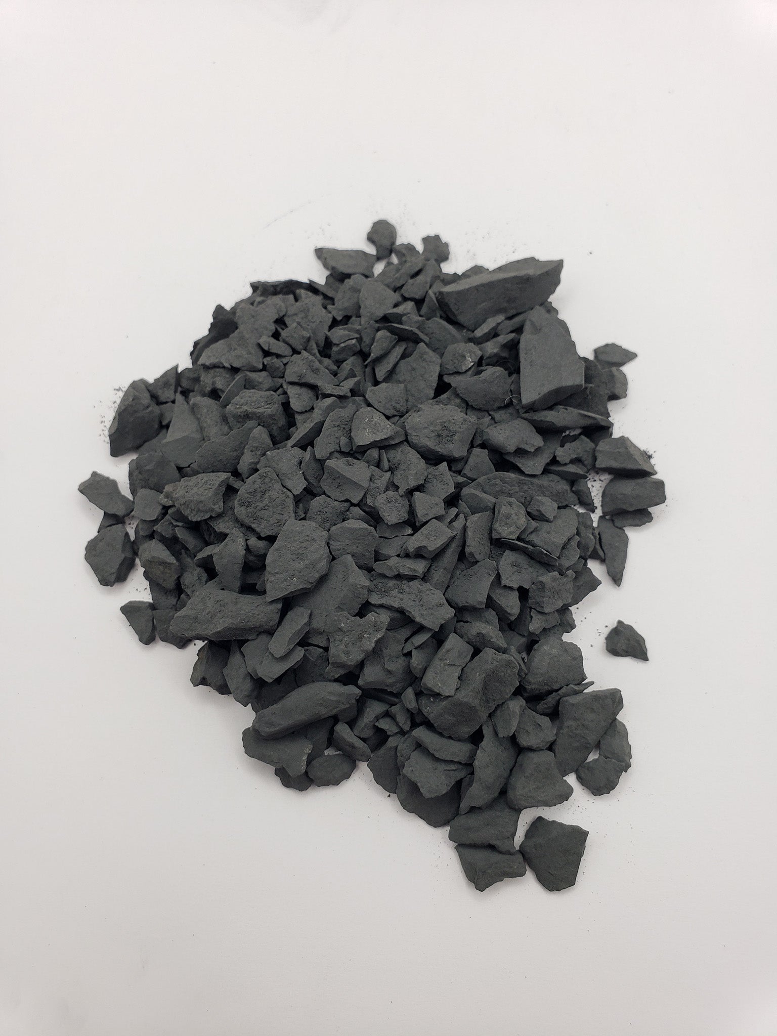 rough shungite stone chips on white background