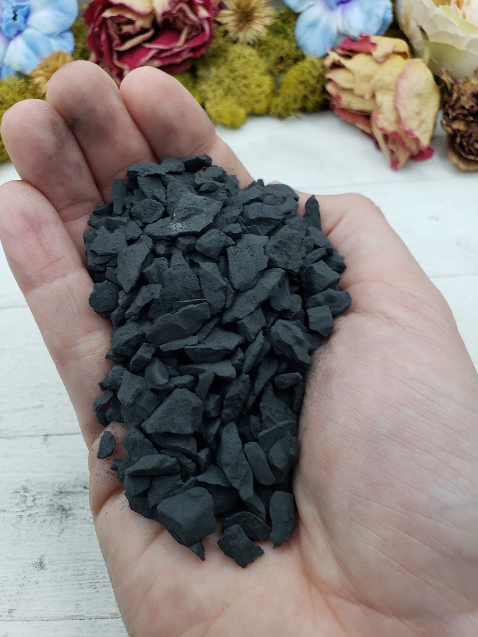 hand holding rough shungite stone chips