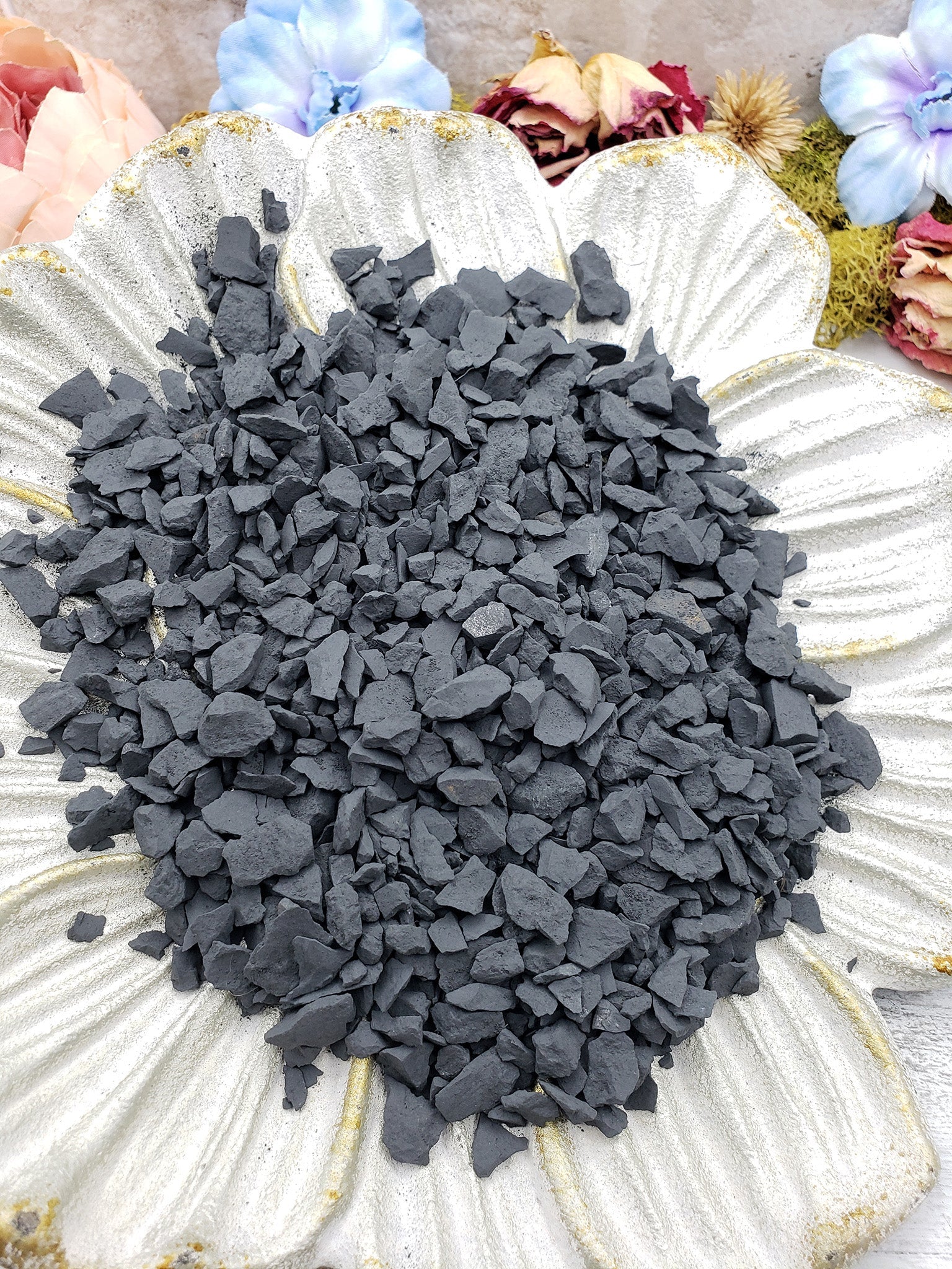 rough shungite stone chips on floral dish display