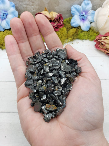hand holding pieces of raw shungite