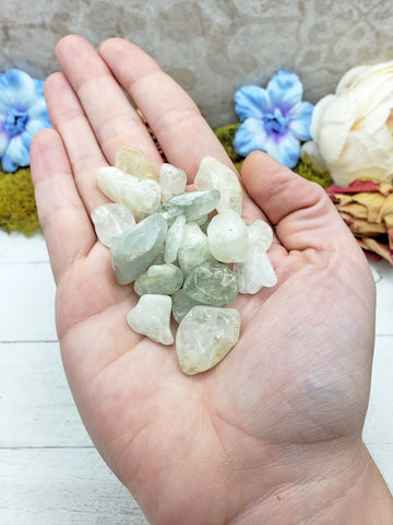 tumbled aquamarine stone pieces in hand