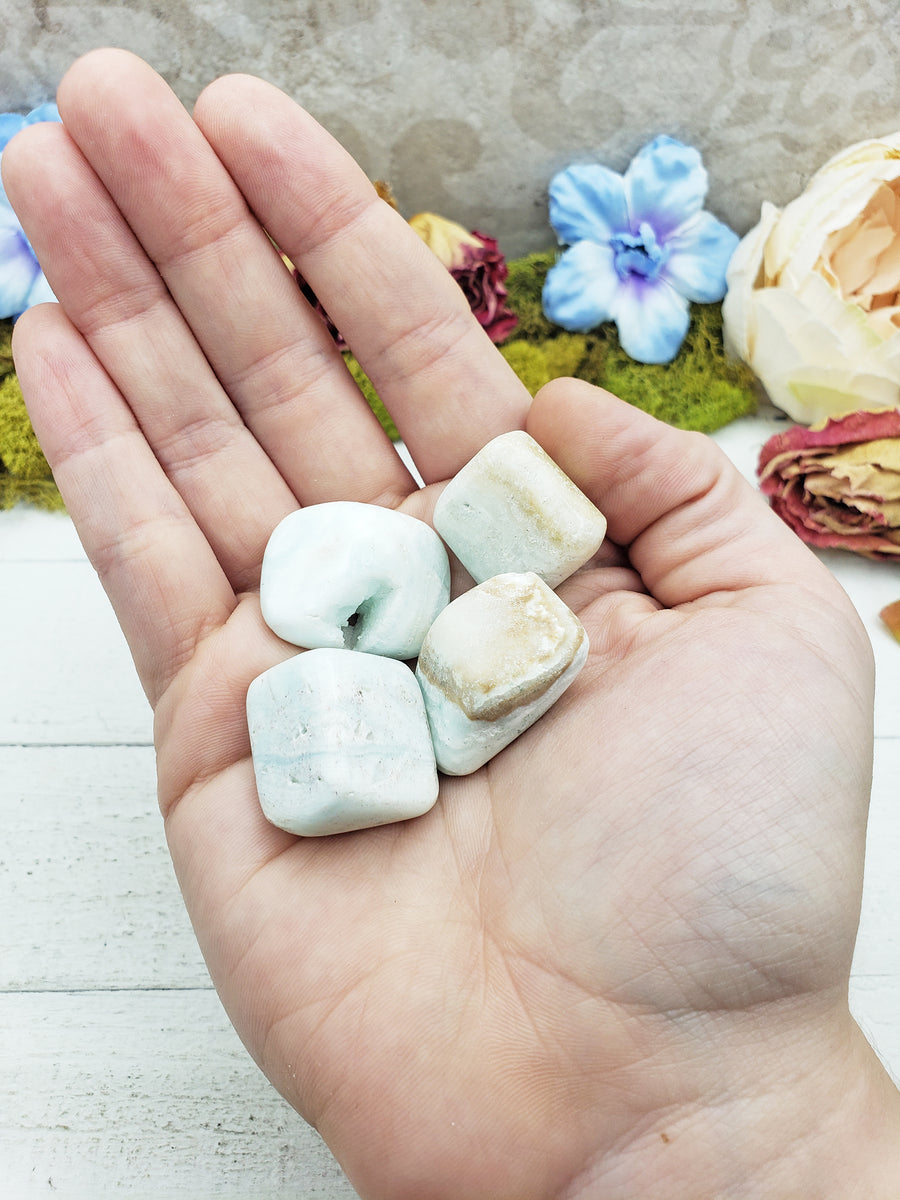 blue ocean caribbean calcite stones in hand