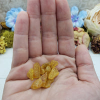 hand holding 3 grams of amber stone chips