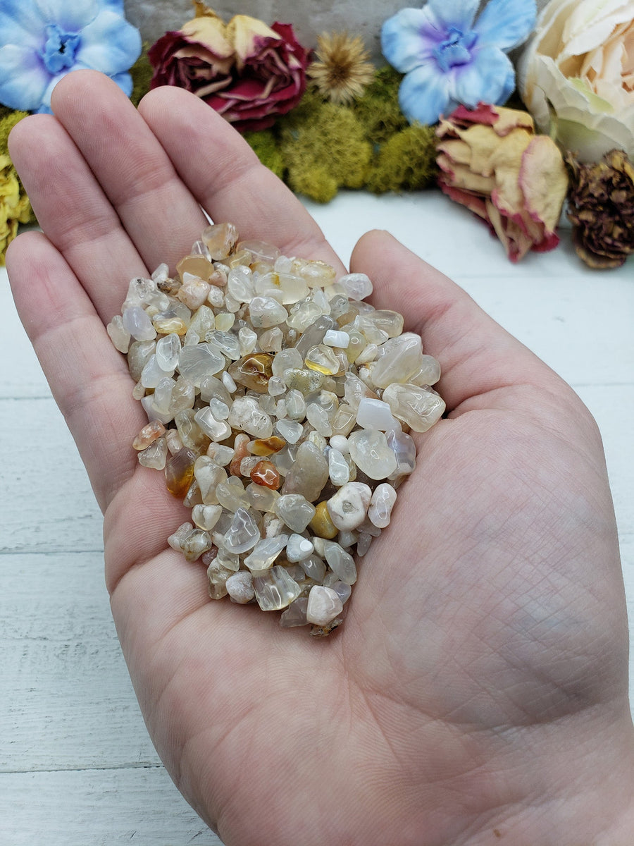 hand holding three ounces of cherry blossom agate chips