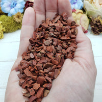 hand holding three ounces of red jasper stone chips