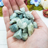 rough aquamarine stones in hand