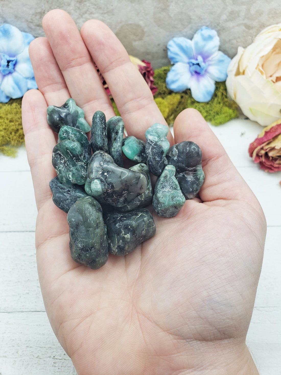 emerald in matrix stones in hand