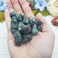 emerald in matrix stones in hand