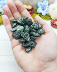tumbled seraphinite stones in hand