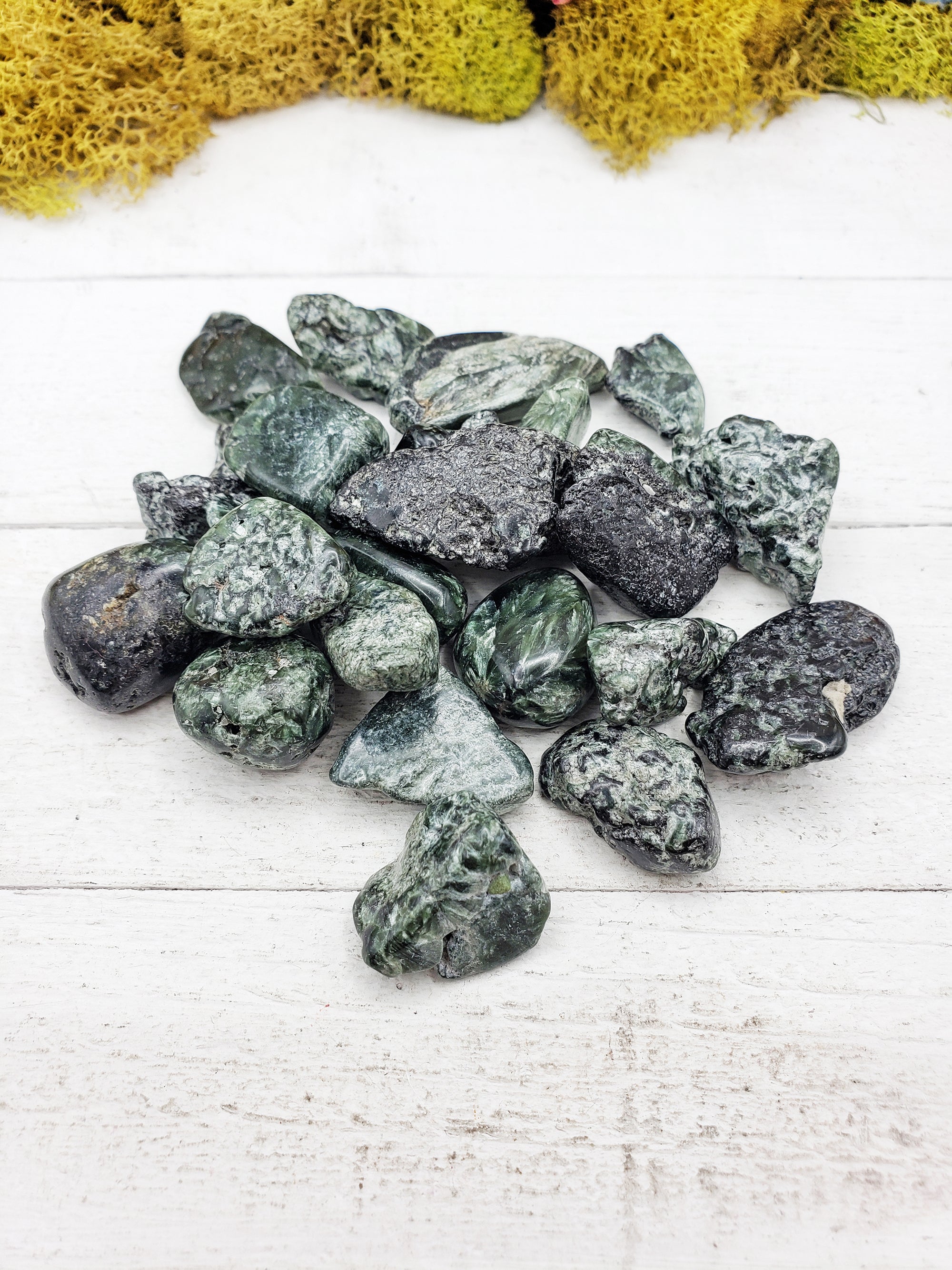 tumbled seraphinite stones on board