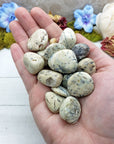 hand holding many white opal stones