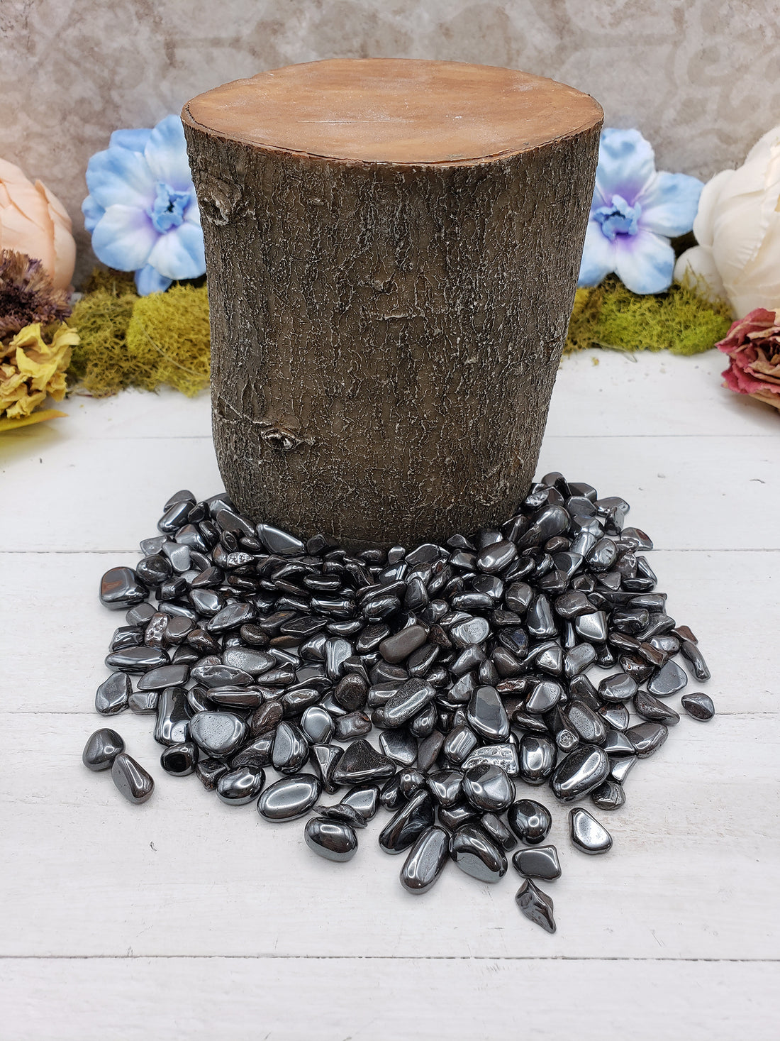 tumbled mini hematite chips by a wooden prop log