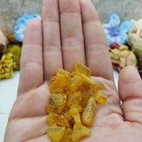 hand holding 9 grams of amber stone chips