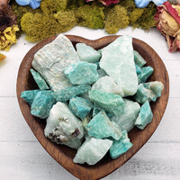 Rough amazonite crystal stones in wooden bowl