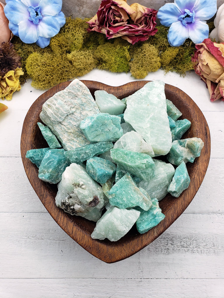 Rough amazonite crystal stones in wooden bowl