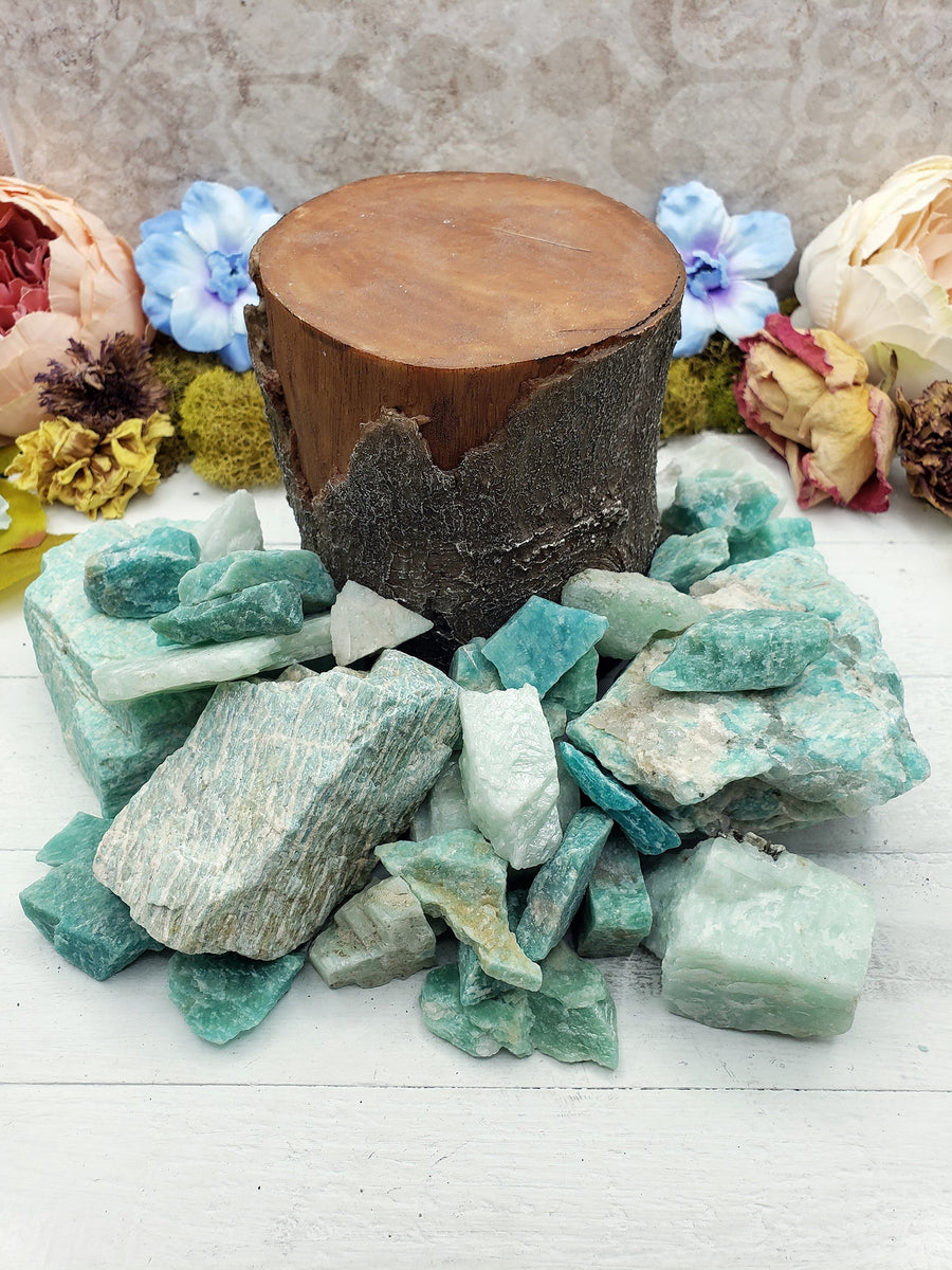 Rough amazonite crystals by wood log prop