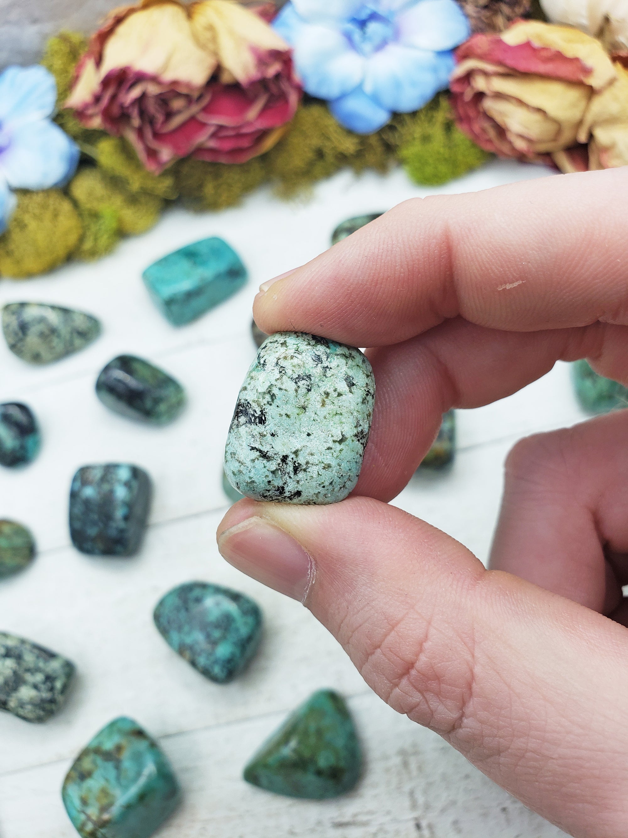 african turquoise stones between fingers