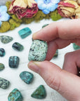 african turquoise stones between fingers