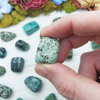 african turquoise stones between fingers