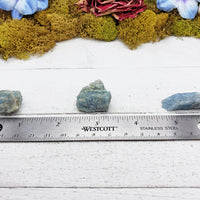 rough aquamarine stones on ruler