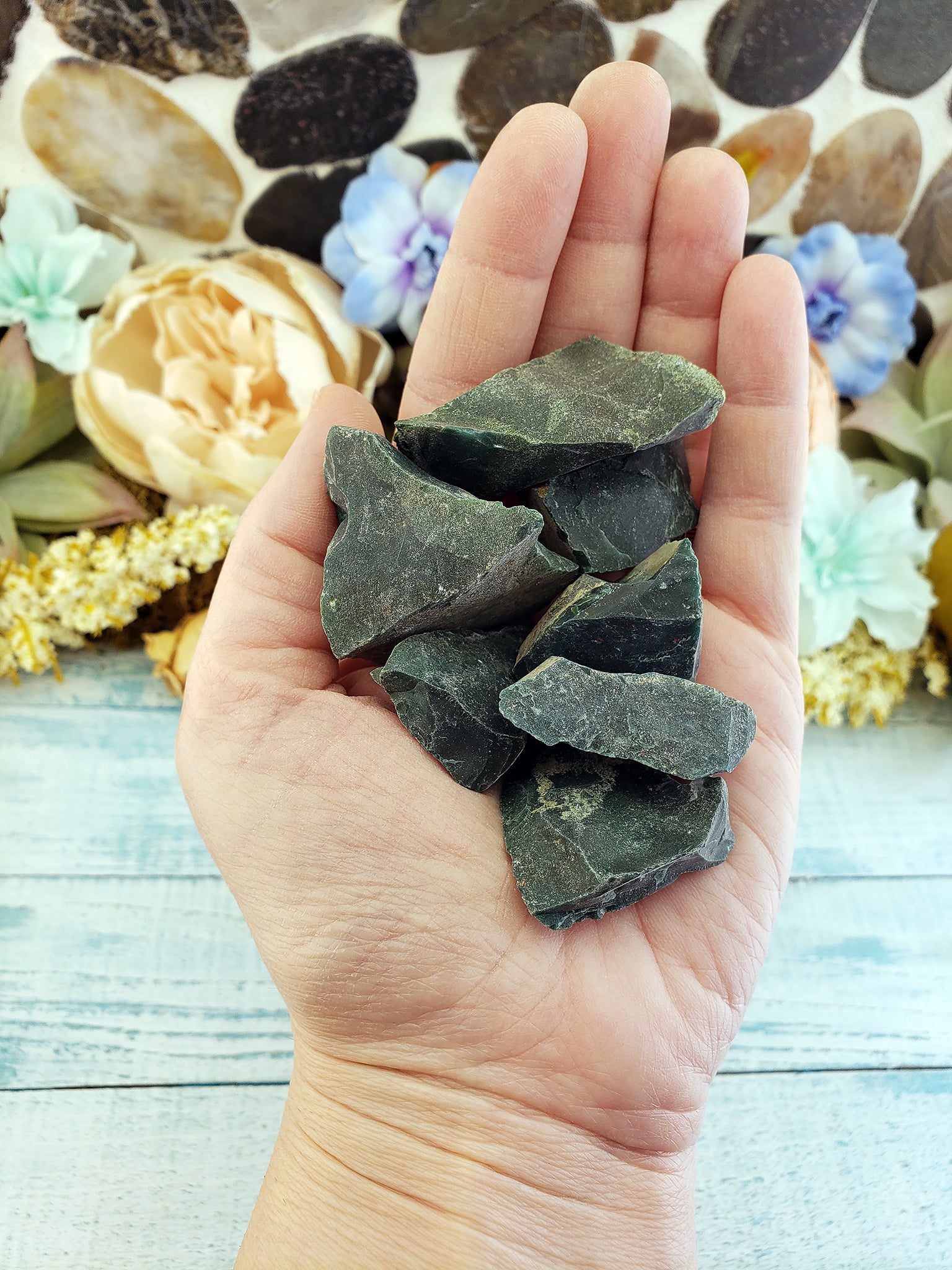 Hand holding rough bloodstone crystal pieces